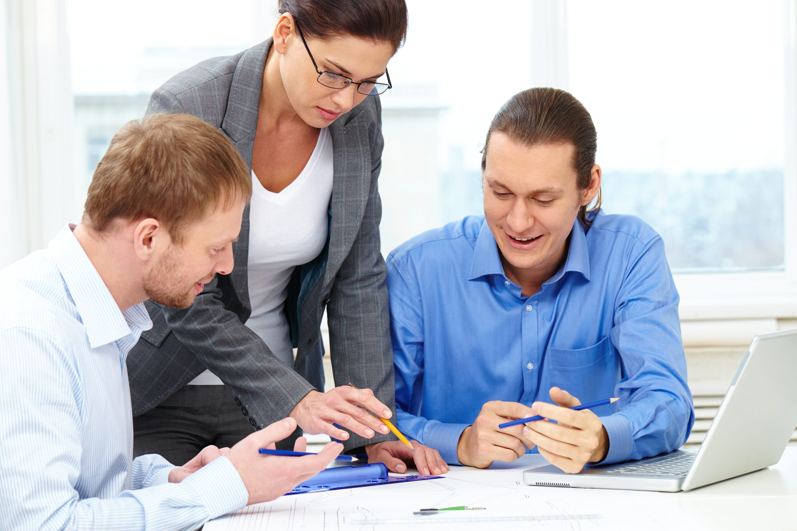 Three businesspeople sitting at table and discussing a project
